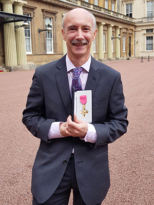 David Martin holding his OBE